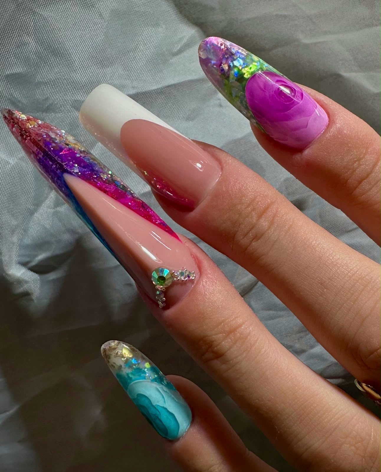 Nail art multicolore con decorazioni e cristalli